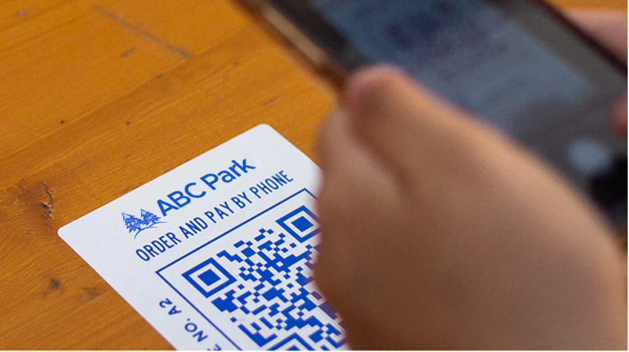 How do amusement parks maintain a touchless park experience with QR codes?
